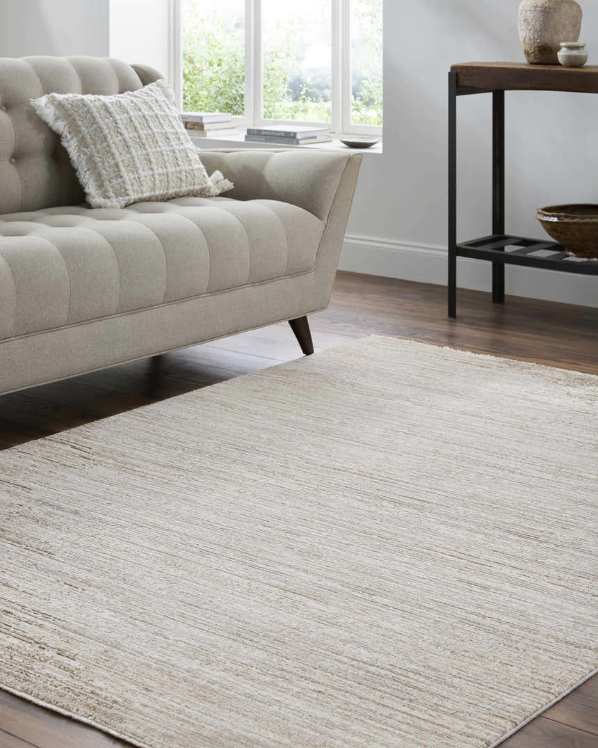 Living room scene with ash-colored Atarah Area Rug, beige sofa, wood floors, and natural light. Roomscene-Rectangle