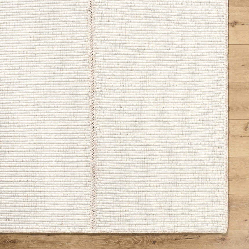 Close up of the neutral Xowi Global Modern wool rug showing hand woven texture and detail. Corner