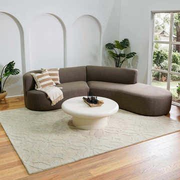 Living room scene with a Fyffe Embossed Beige Wool Area Rug, brown sectional sofa, and white coffee table. Roomscene-Rectangle
