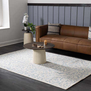 Living room scene with a Gagebrook Blue Wool Area Rug, brown leather sofa, and round coffee table. Roomscene-Rectangle