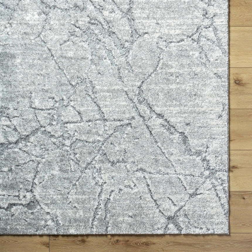 Close-up of the Genkei Black Area Rug showing its charcoal and light gray abstract pattern and soft texture. Corner