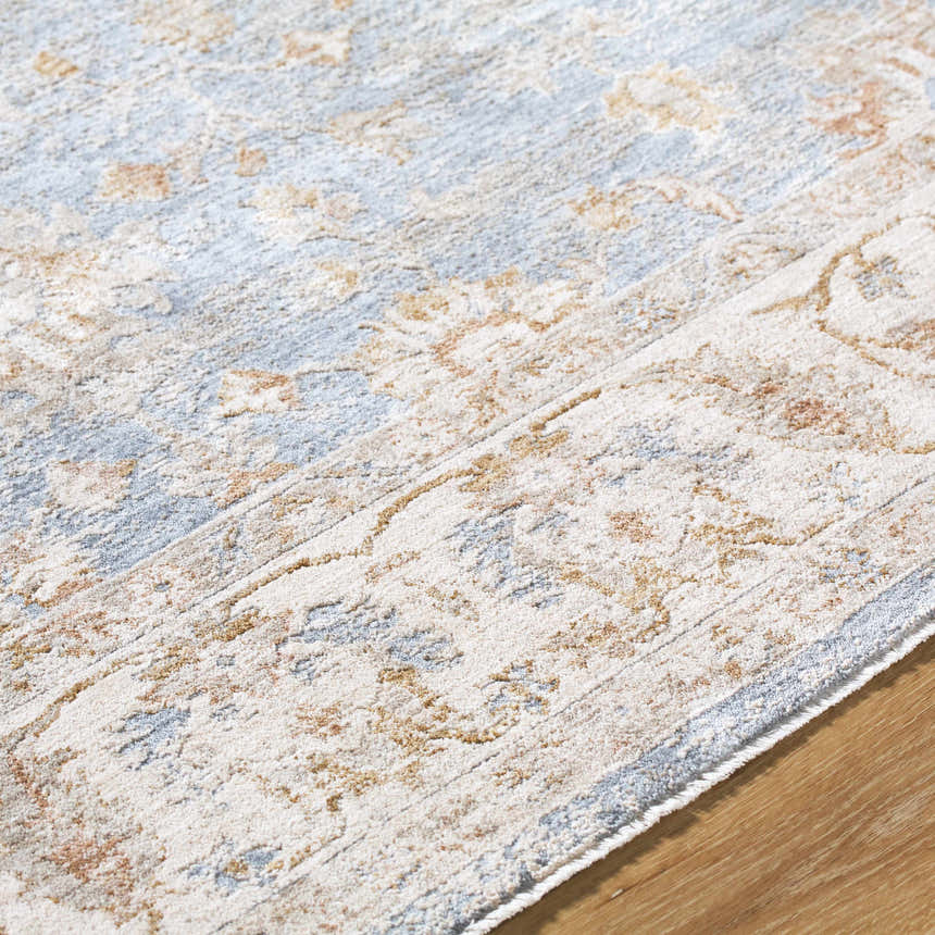 Close up of the Avivit Sage Area Rug. Farmhouse style rug with blue, cream, sage, and tan floral pattern. Texture