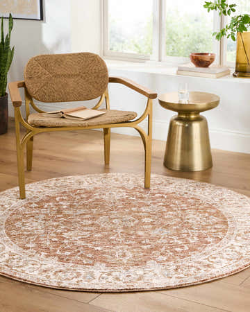 Sunlit room featuring a round Avivit Cream Area Rug, woven chair, and gold accent table. Roomscene-Round