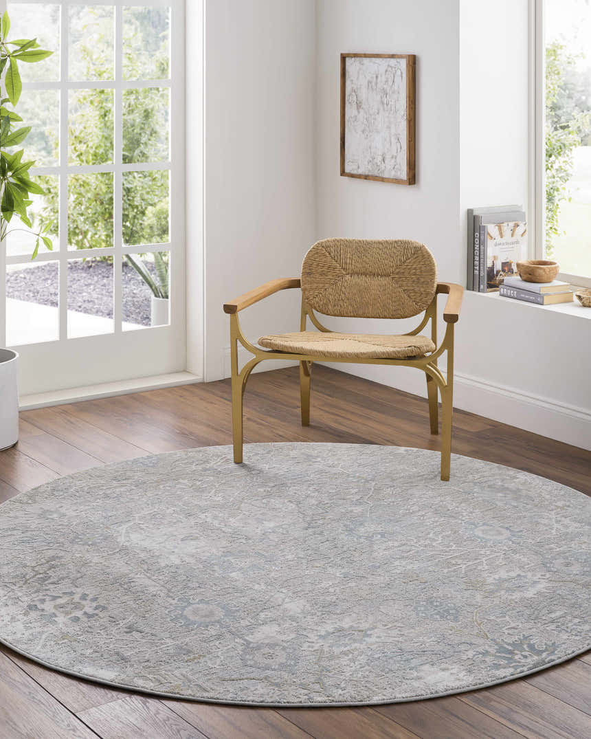 Bright room featuring a round Gilmanton Thick Luxe Boutique Rug in dusty sage and gray under a woven chair. Roomscene-Round