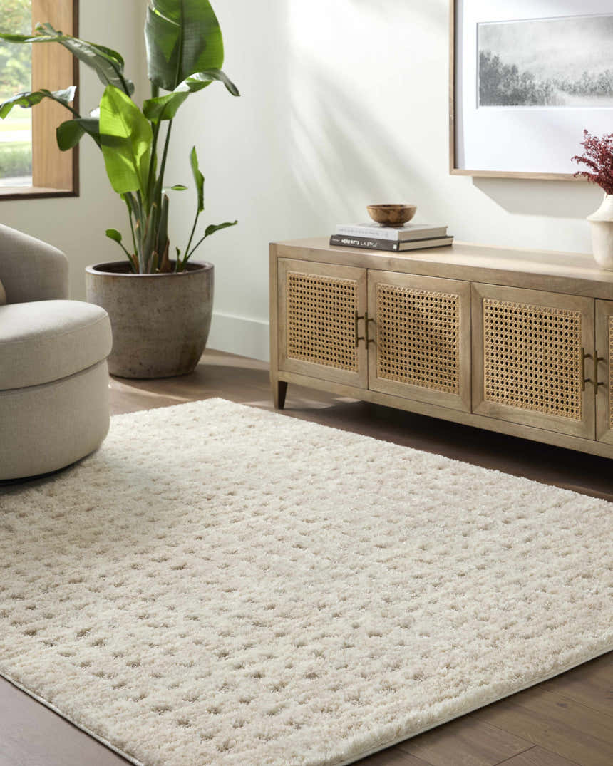 Living room scene with a cream Armand Luxe Shag Rug, light wood media console, and neutral swivel chair. Roomscene-Rectangle
