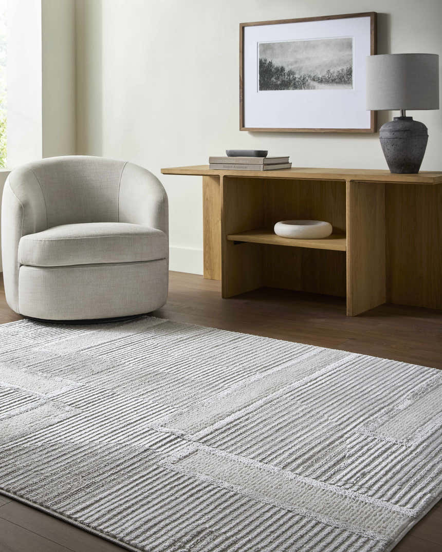 Contemporary living room with Atalie Area Rug, light gray chair, and wood console table. Roomscene-Rectangle