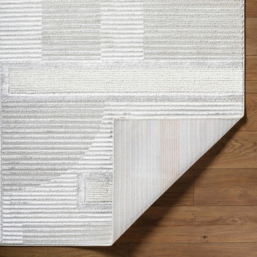 Close-up of the Atalie Area Rug showing its cream, ivory, and gray stripes and geometric pattern. Fold