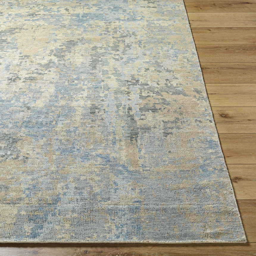 Close-up of the Greenhills Handmade Wool Area Rug, showcasing its beige, blue, and gray contemporary pattern on wood floors. Front
