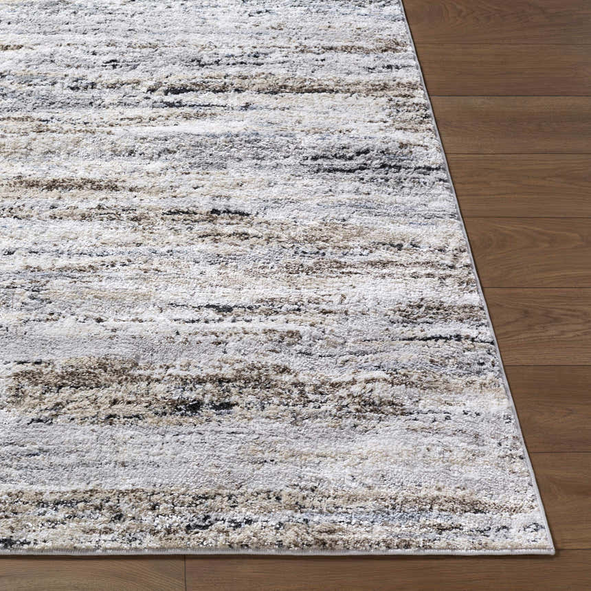 Close-up of the Aurera Area Rug. Contemporary style with black, ivory, gray, and brown abstract pattern. Machine woven texture. Front