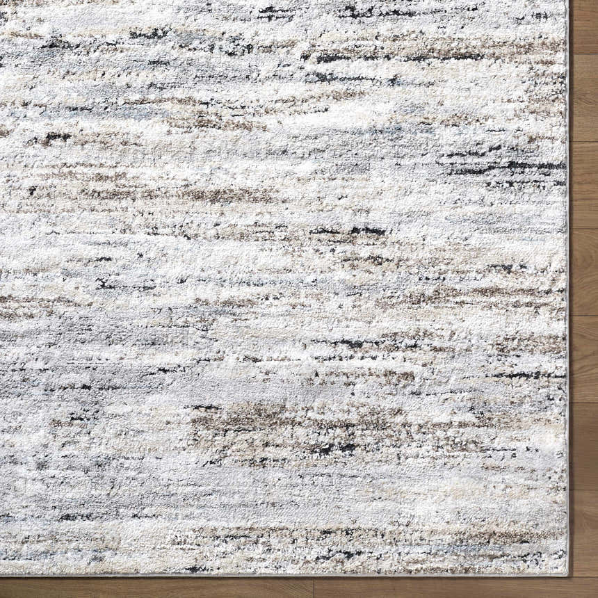 Close-up of the Aurera Area Rug. Contemporary design in ivory, black, brown, and gray on a machine-woven polypropylene rug. Corner