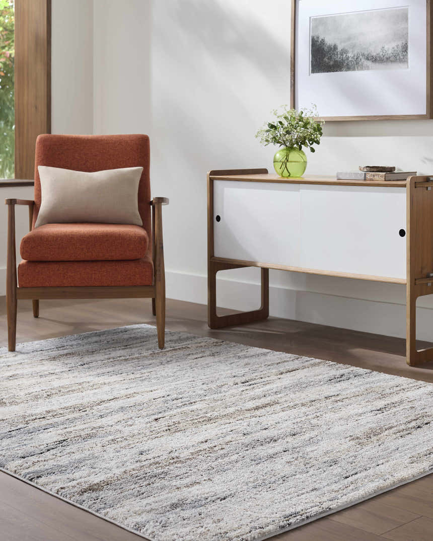 Living room scene with a contemporary Aurera Area Rug in black, ivory, and gray, styled with a mid-century modern chair and sideboard. Roomscene-Rectangle
