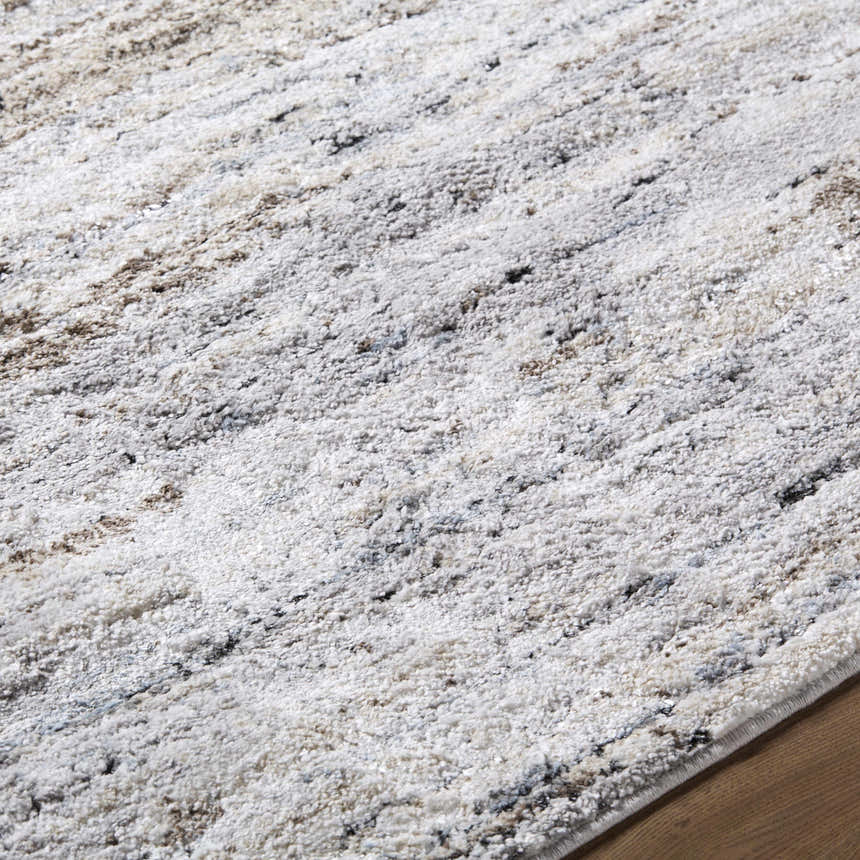 Close-up of the Aurera Area Rug. Contemporary style with black, ivory, brown, and gray hues. Machine woven texture. Texture