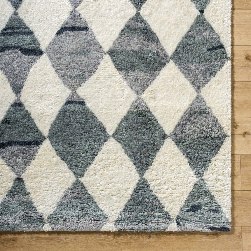 Close-up of the hand-tufted Azaria Baklava Wool Rug. Gray and light silver diamond pattern on a farmhouse style rug. Corner