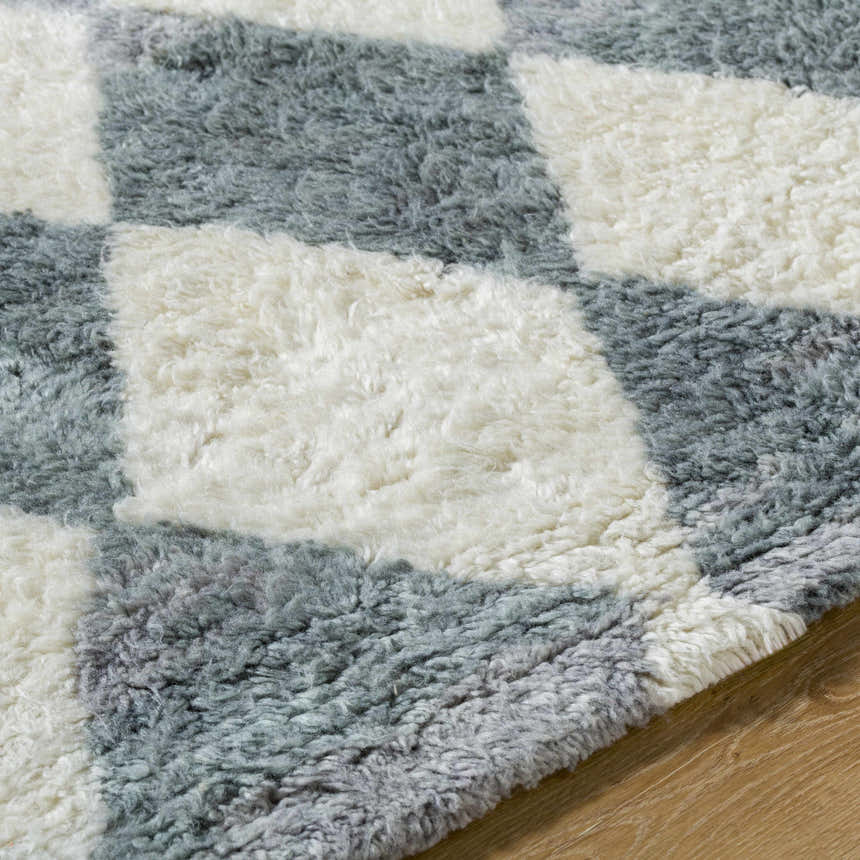 Close-up of the Azaria Baklava Wool Rug, showing its gray and white checkerboard pattern and hand-tufted texture. Texture
