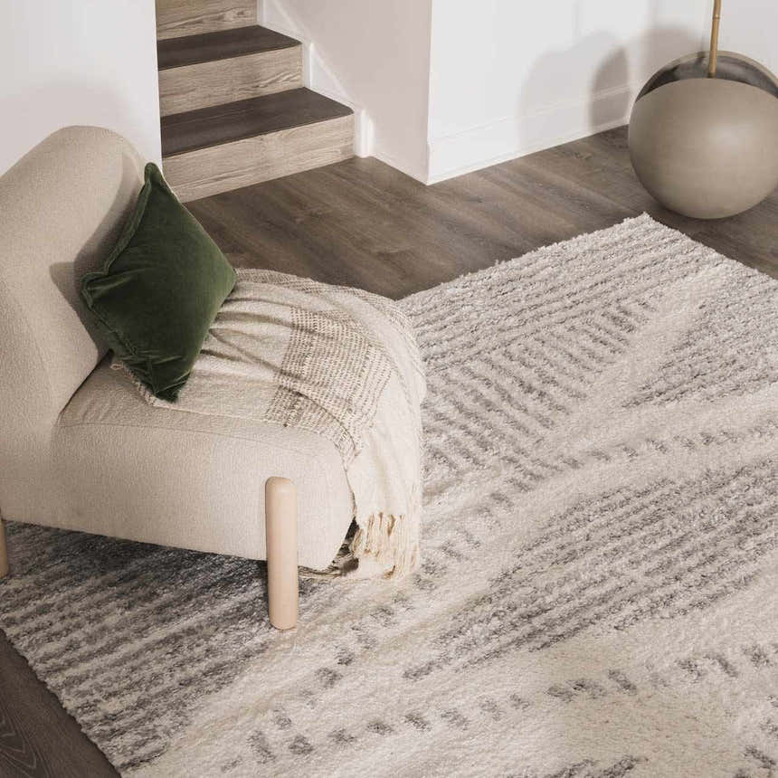 Living room scene with a Trunding Plush Area Rug in Gray, cream chair, and wood floors. Roomscene-Rectangle