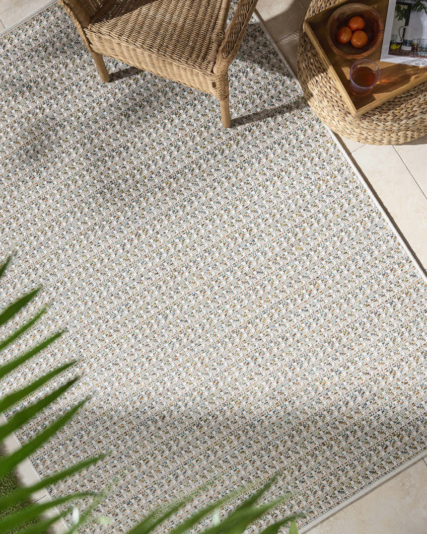 Top-down view of a patio with wicker furniture and the Ataret Ivory Area Rug. Roomscene-Rectangle