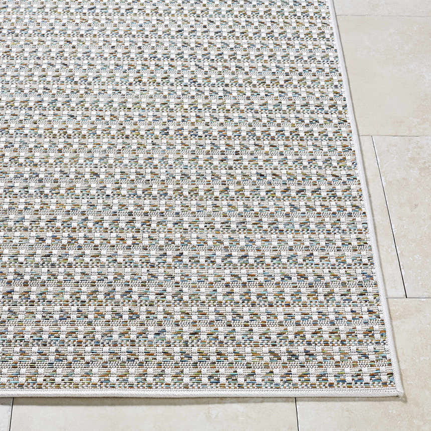 Close-up of the Ataret Ivory Area Rug. Woven texture with charcoal, ivory, sky blue, slate gray, and tan colors. Front