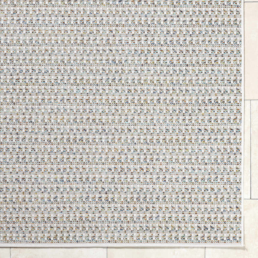 Close-up of the Ataret Ivory Area Rug showing its woven texture and ivory, tan, and blue color palette. Corner