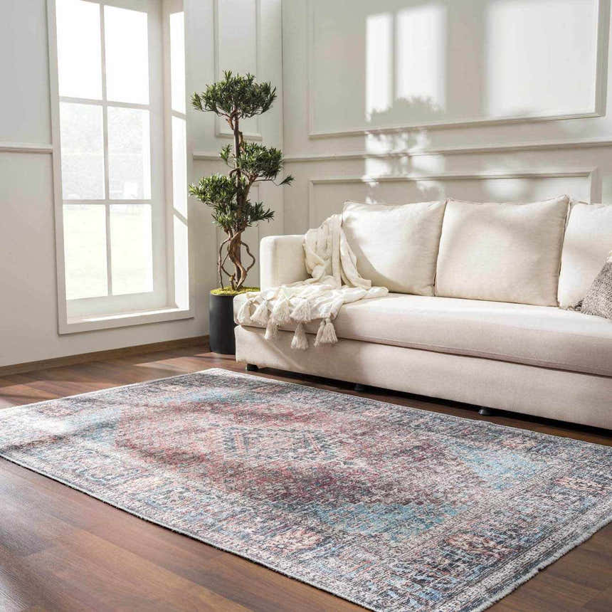 Living room scene with a Blue Burgundy Holi-2302 rug, cream sofa, wood floors, and natural light from a large window. Roomscene-Rectangle