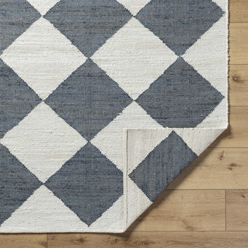 Close-up of the hand woven Andrin Gray Area Rug. Beige and steel gray checkered pattern made of 100% jute. Fold