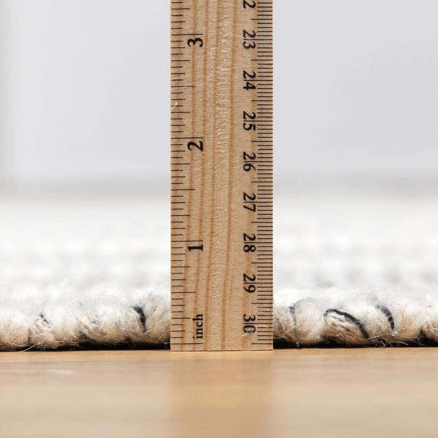 Close-up of the pile height of the hand woven New Whittington Area Rug, medium gray and off white wool. Pile