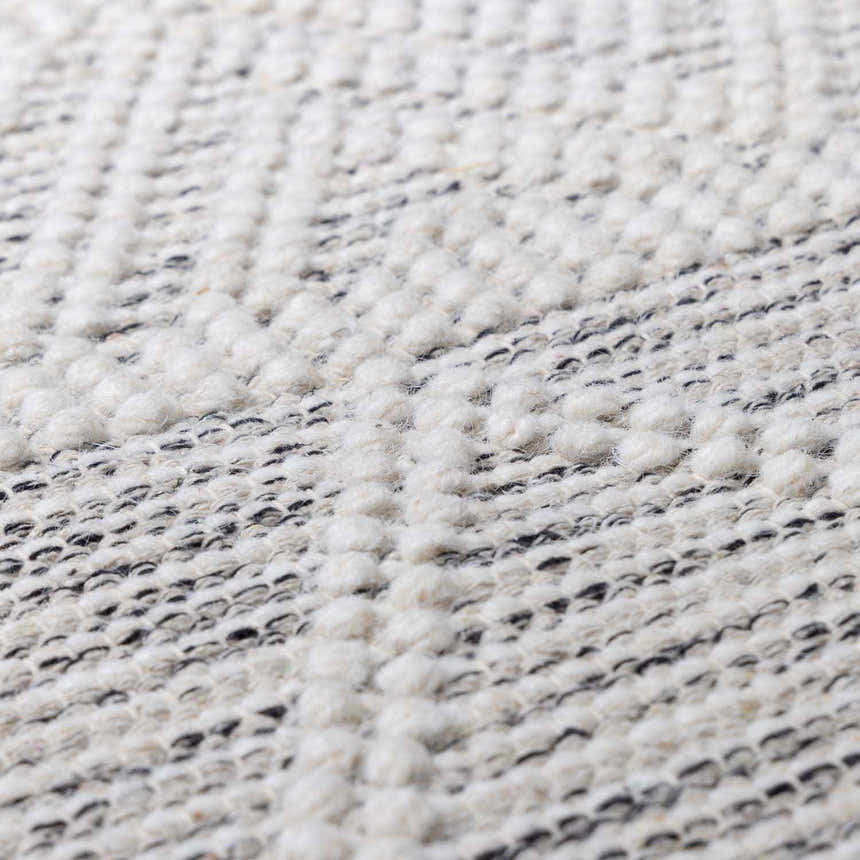 Close-up of the hand woven New Whittington Area Rug. Off white wool with a medium gray geometric pattern. Texture