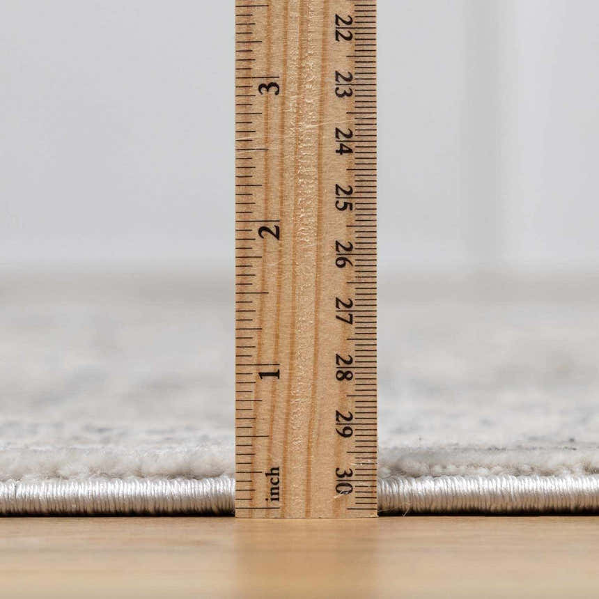 Close up of the New Parkerfield area rug pile height, with a ruler showing the thickness. Pile