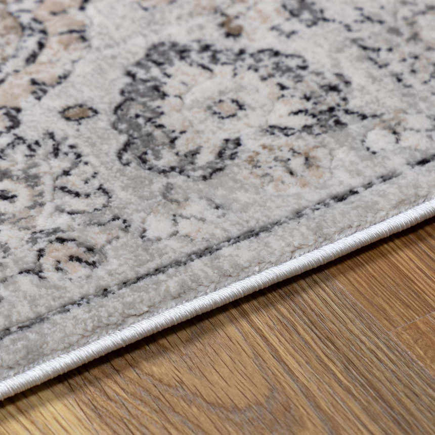Close-up of the beige and gray Parkerfield Area Rug showing its traditional vintage pattern and soft texture. Corner
