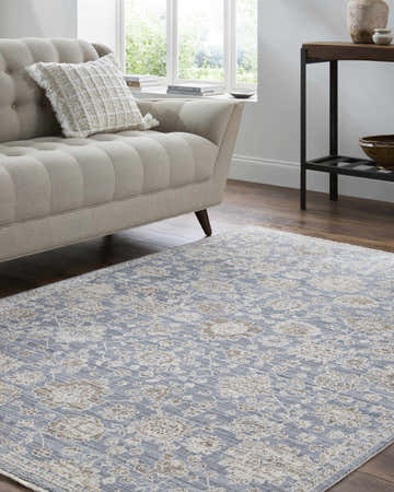 Living room scene with a beige sofa and the Urara Blue Area Rug featuring a traditional floral pattern. Roomscene-Rectangle