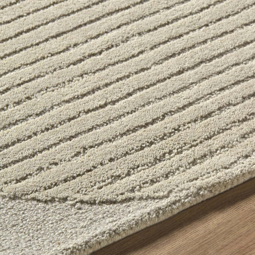 Close up of the Ecru Abstract Modern Hand Tufted Wool Area Rug showing its textured, striped design and wool fibers. Texture