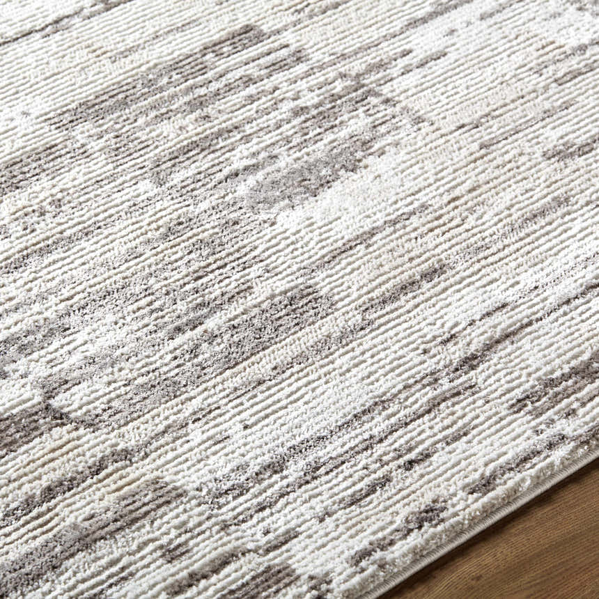 Close up of the Apphia Area Rug, featuring an ivory and light brown contemporary pattern. Texture
