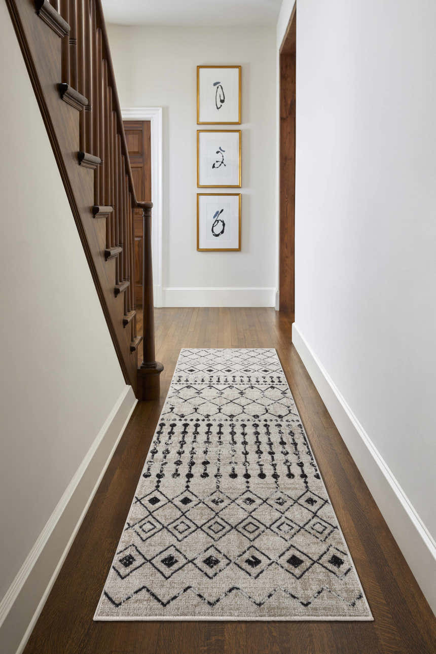 Hallway with wood floors and a black and cream Joppatowne Washable Area Rug runner leading to a staircase. Roomscene-Runner