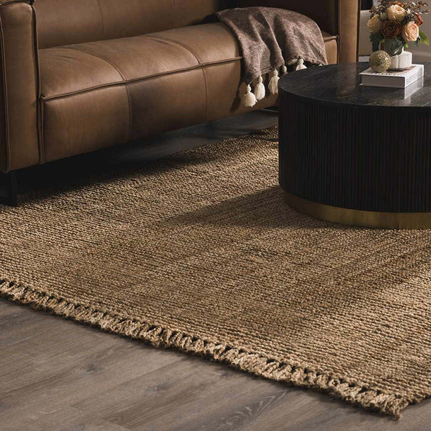 Living room scene with a brown leather sofa and the Oaks Perfect Flatweave Jute Rug in natural beige. Texture