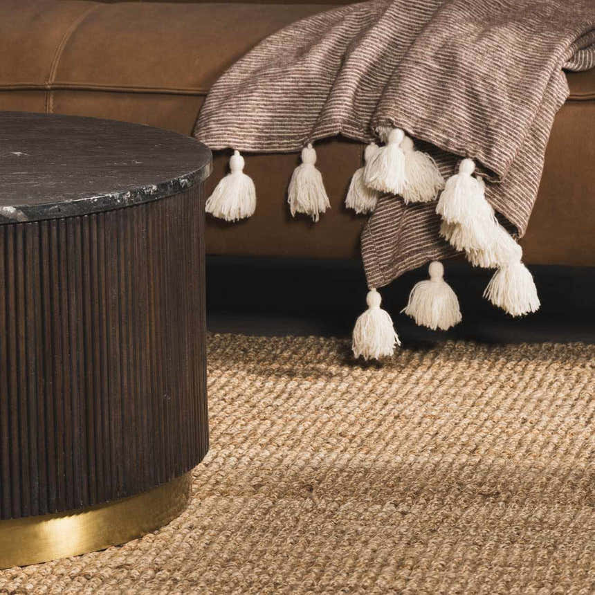 Close-up of the woven texture and natural beige color of the Oaks Perfect Flatweave Jute Rug in a styled living room. Styleshot