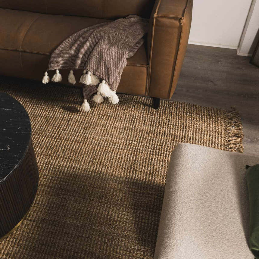Living room scene with a brown leather sofa and a natural fiber Oaks Perfect Flatweave Jute Rug. Styleshot