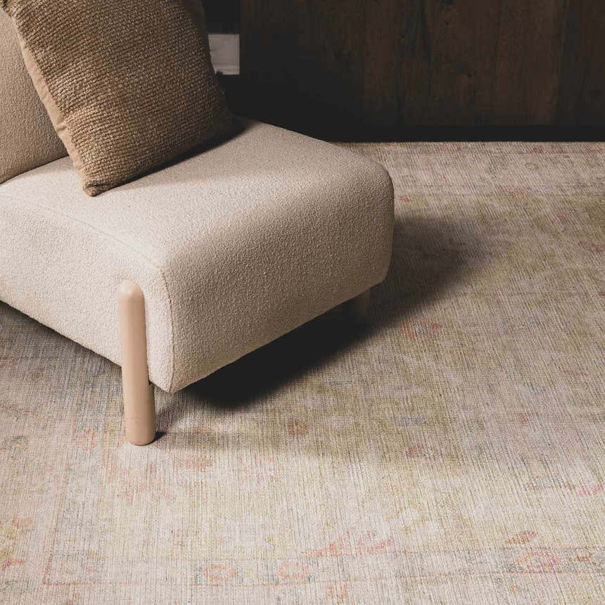 Close-up of the Bozkurt Boutique Washable Rug in a living room setting with a chair in lambswool color. Roomscene-Rectangle