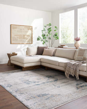 Light-filled living room with a neutral sectional and the Kalare Light Gray Area Rug adding subtle pattern to the wood floor. Roomscene-Rectangle