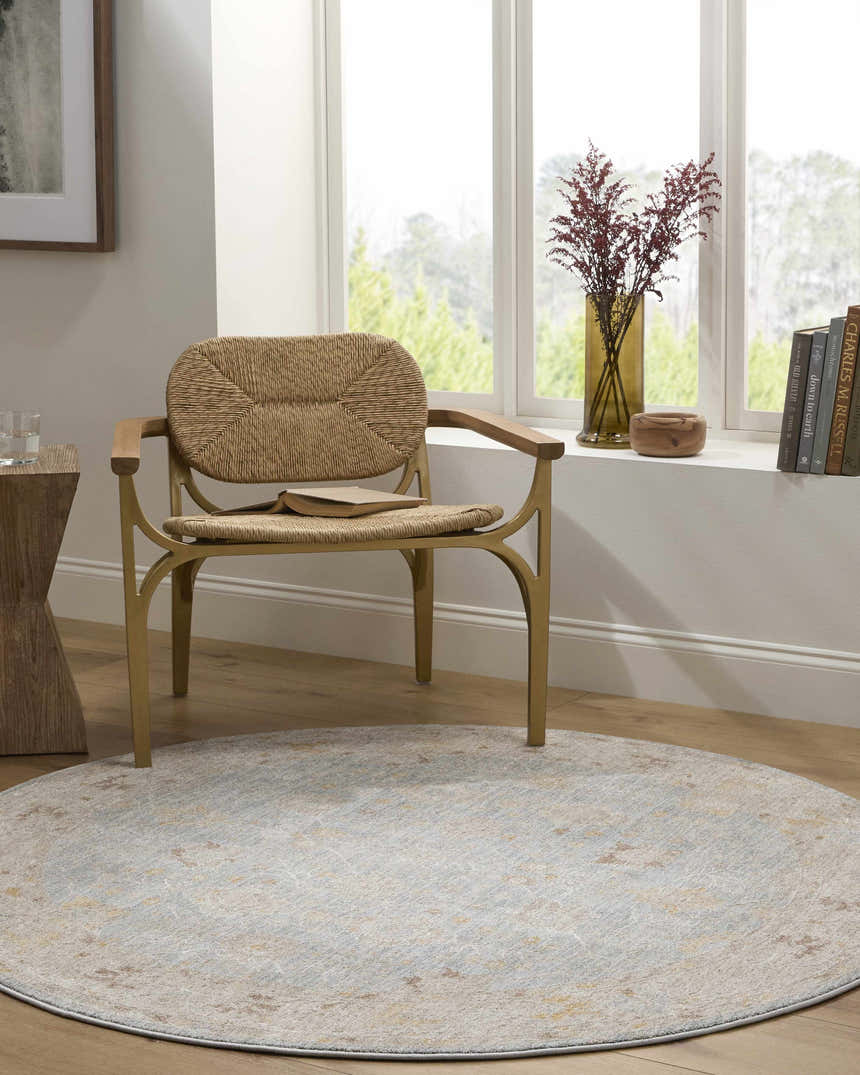 Light-filled room with a round Kofi Thick Luxe Area Rug, woven chair, and natural wood accents. Roomscene-Round