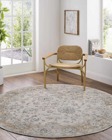 Bright room scene with a round Kerem Cream Thick Luxe Damask Rug, a woven chair, and natural light. Roomscene-Round