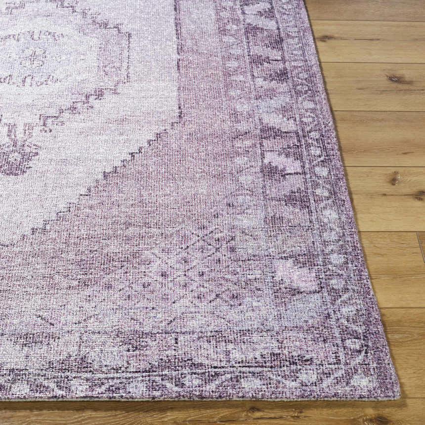 Close-up of the hand-tufted Wayde Area Rug. Dusty rose, lavender, and mauve traditional pattern on a polyester rug. Front