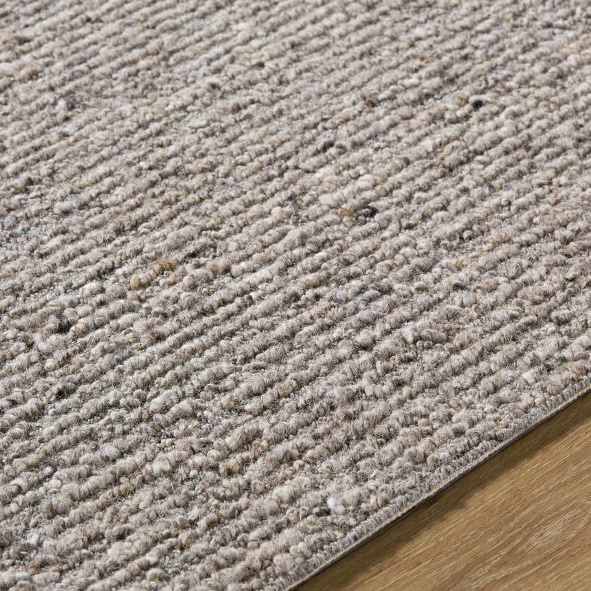 Close-up of the hand-tufted Winta Taupe Wool Area Rug. Neutral tan, gray, and sage tones with a textured, looped pile. Texture