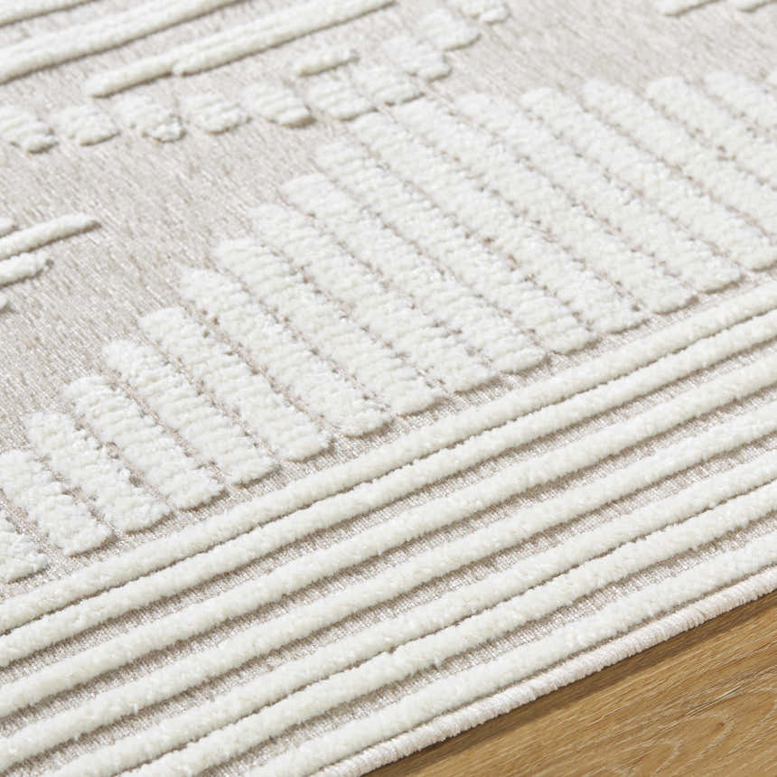 Close up of the Annika Washable Area Rug, off white and tan farmhouse style with a geometric pattern. Texture
