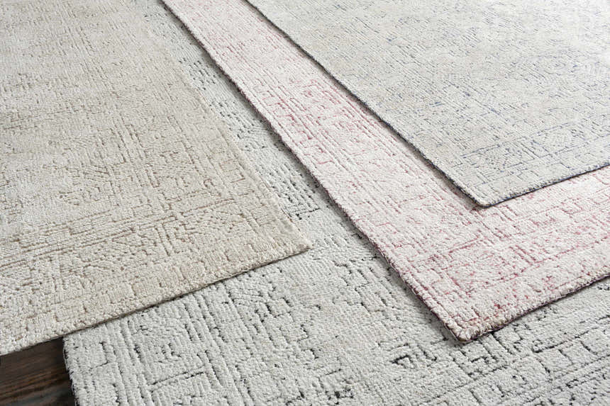 Close-up of the textured Ipplepen Area Rug - Clearance, featuring a geometric pattern in blue, white, and pink hues. Styleshot