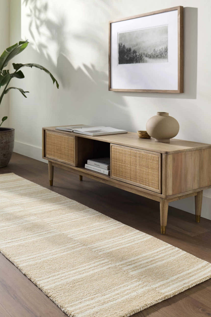 Living room scene with a beige and ivory striped Argyro Area Rug runner under a wood media console. Roomscene-Rectangle