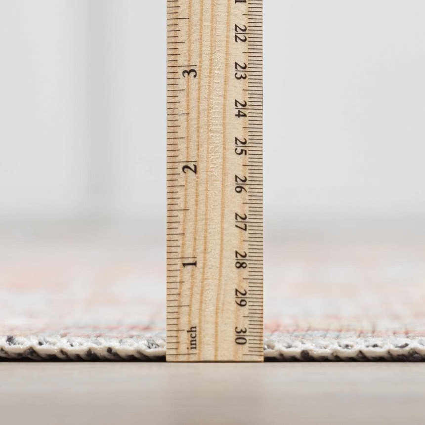 Close-up of the Rust Maayon Washable Rug pile height, showing a low profile with brick red and brown colors. Pile