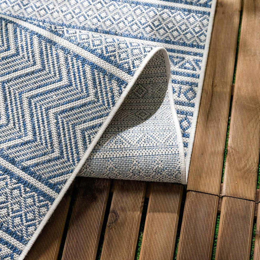 Close-up of the Madras Light Blue Green All Over Performance Area Rug showing its geometric pattern and texture. Fold