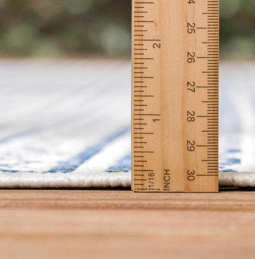 Close-up of the Madras Light Blue Green All Over Performance Area Rug pile height, measured with a ruler. Pile