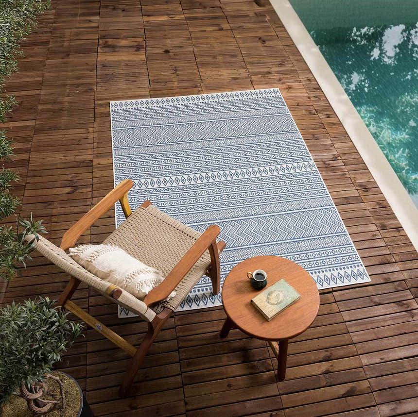 Outdoor patio scene with Madras Light Blue Green rug, chair, and side table by pool. Roomscene-Rectangle