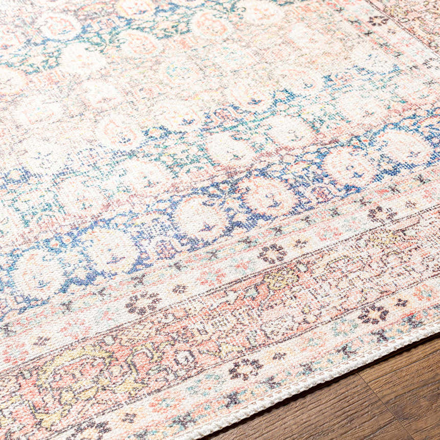 Close-up of the Maligaya Distressed Washable Rug with bone, gray, and nutmeg tones on hardwood floor. Persian style. Texture