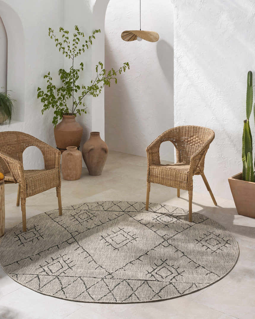 Bohemian patio with a round Marwood Nordic Performance Rug, wicker chairs, and neutral tones. Roomscene-Round